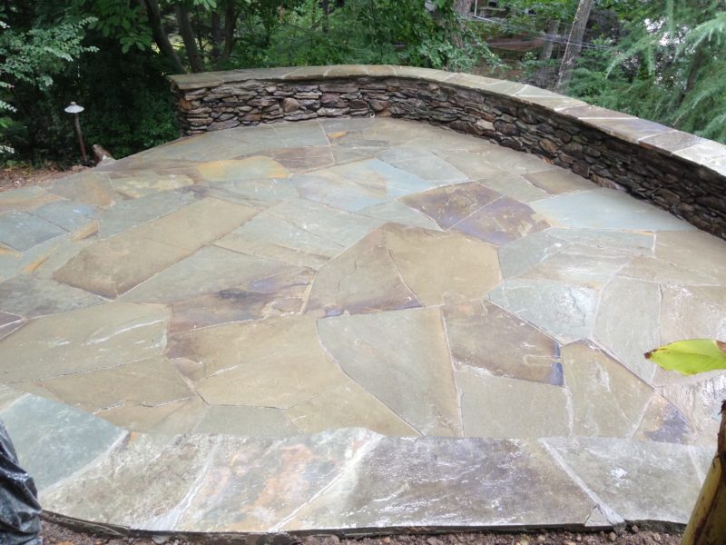 Irregular flagstone patio and weathered dry stack wall.